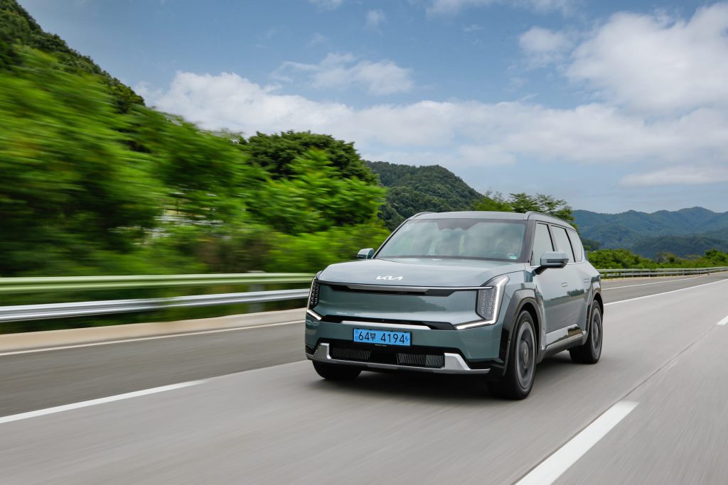 KIA EV9 de vista frontal color verde en movimiento en la carretera